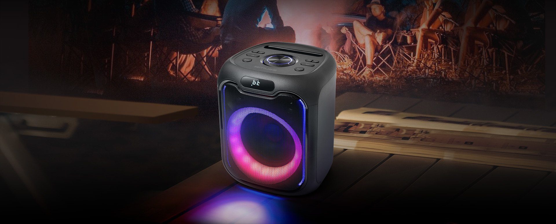 A MUSE party speaker lit with colour-changing lights in a darkened room